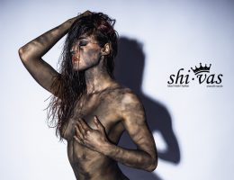 Nahaufnahme von Linas Oberkörper, eine Hand bedeckt schützend eine Brust.