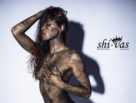 Nahaufnahme von Linas Oberkörper, eine Hand bedeckt schützend eine Brust.