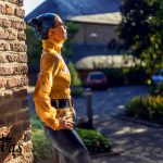 Coco im Profil, sie blickt sehnsüchtig in die Ferne. Man sieht das Tattoo in ihrem Nacken und den hohen Kragen der Bluse.