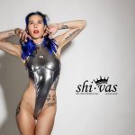 Coco im extremen Highcut-Body aus reflektierendem Silber. Der dünne Stoff zeichnet Brust und Nippelpiercings deutlich ab, die Beine wirken endlos. Provokanter Fetish-Look zum Jahresauftakt, selbstbewusst und sexy im Studio.