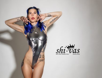 Coco im extremen Highcut-Body aus reflektierendem Silber. Der dünne Stoff zeichnet Brust und Nippelpiercings deutlich ab, die Beine wirken endlos. Provokanter Fetish-Look zum Jahresauftakt, selbstbewusst und sexy im Studio.