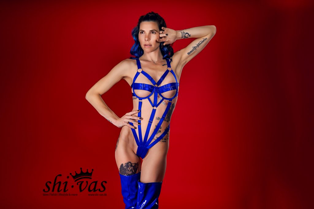 Coco mit einer Hand an der Hüfte, die andere am Kopf, blickt siegessicher zur Seite.