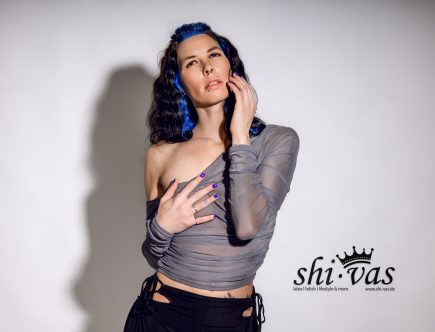 Portrait/Halbaufnahme, Off-Shoulder, Kopf zurück, rechte Hand an der Wange, linke Hand flach auf der Brust.