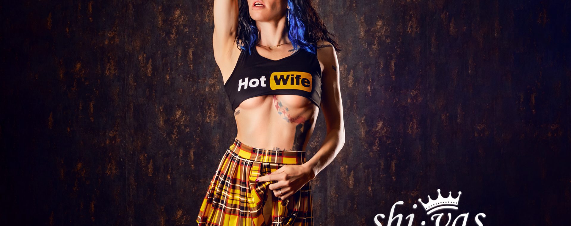 Coco hebt einen Arm über den Kopf, trägt Crop-Top und Minirock, der Körper ist gestreckt und leicht zur Seite gedreht