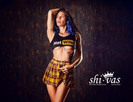 Coco hebt einen Arm über den Kopf, trägt Crop-Top und Minirock, der Körper ist gestreckt und leicht zur Seite gedreht