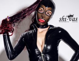 Close-Up von Coco mit Feitico-Latexmaske, rotem Lippenstift und leicht geöffnetem Reißverschluss.